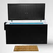 Black cold plunge with open lid and a wooden mat on a white background