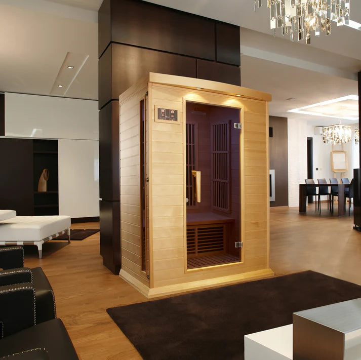 Infrared sauna in a modern living room setting with wooden interior and glass door.